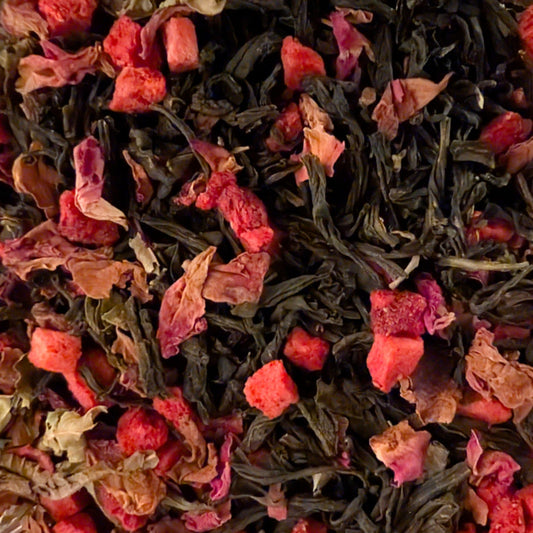 Tea leaves with pink and red flowers on a dark background
