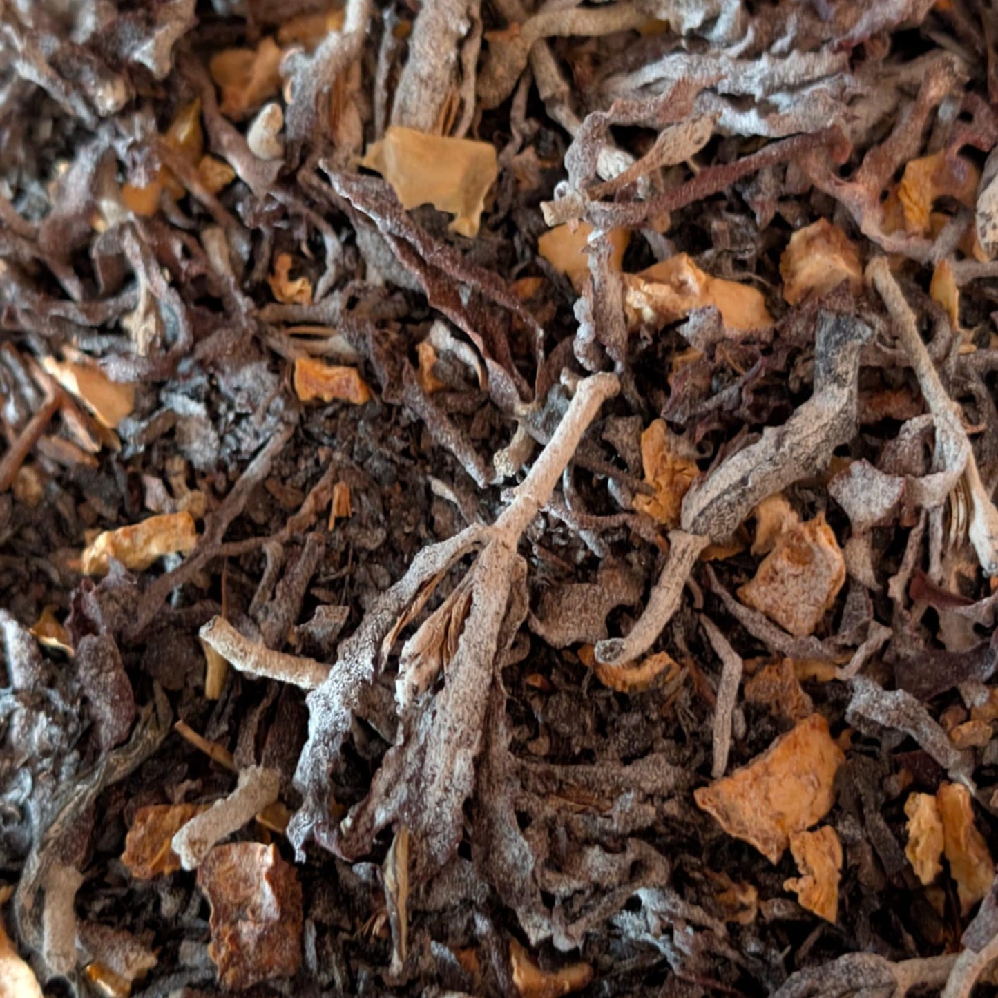 Close-up of dried tea leaves with a brown and orange color.