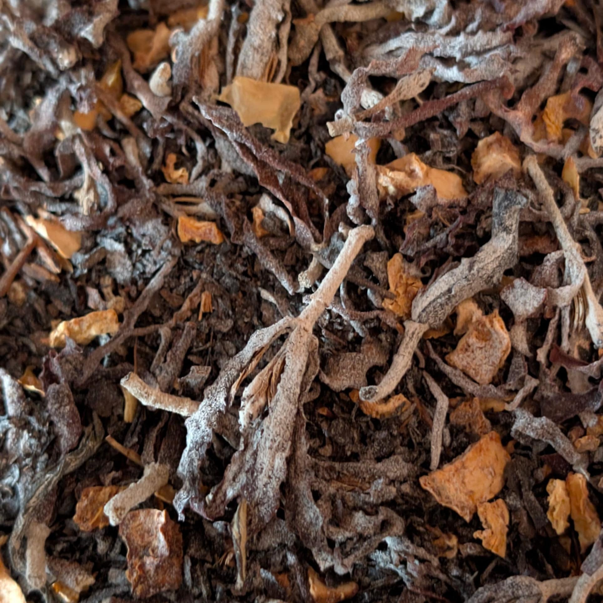 Close-up of dried tea leaves with a brown and orange color.